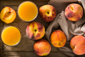 Natural peach juice in glass on wooden table	
