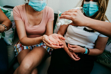 .Group of young girlfriends meeting after the quarantine caused by the covid pandemic19. Taking precaution with the use of surgical masks and cleaning your hands with hydroalcoholic gel. New normal