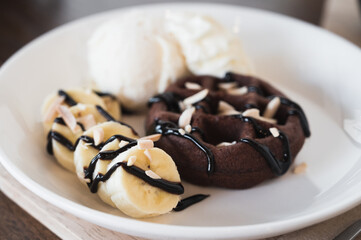 chocolate waffle serve with sliced banana and vanilla ice cream