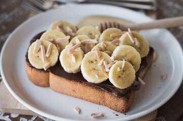 toasted bread topped with chocolate, banana, sliced almond and honey