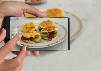Woman photographing on cell phone homemade healthy food.