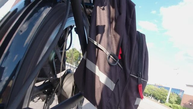 Riding electric bicycle on the city streets at summer day. Camera view to the power batteries and electro motor. Natural lighting. The view of the power battery of e bike. Summer leisure lifestyle.