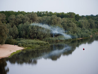 smoke from a fire over a river