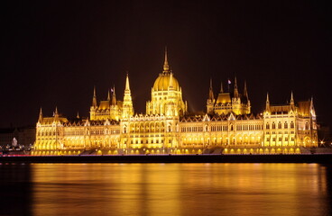 Fototapeta premium Budapest parliament building at night, long exposure. Hungarian Parliament building and Danube River in the Budapest city at night. Neo-gothic architecture, Budapest's tourist attraction