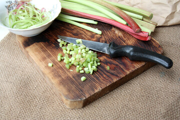 Fresh rhubarb sliced on a cutting board. There is a place for text.
rhubarb on wooden surface
