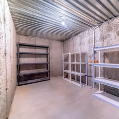 Square Empty multi layer metal racks inside a storage room with concrete wall and floor