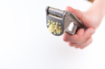 Male hands hold a garlic press or garlic squeezer. Kitchen Tool for preparing and preparing salads, dishes