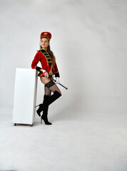 beautiful girl in a red hussar costume with a sword
