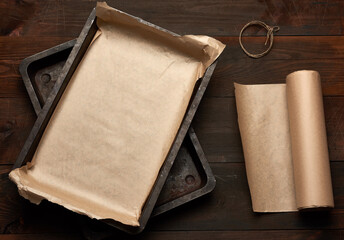 empty rectangular metal pan covered with brown parchment paper and paper rolls