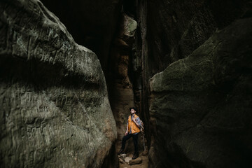 Young male traveler walks in a mountain cave alone
