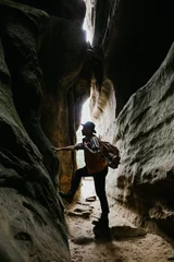 Tuinposter Amateur geologist and speleologist explores a mountain cave. Extreme hobbies © Yevhenii Kukulka