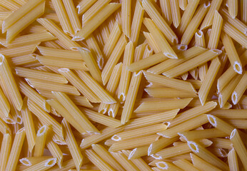 Texture of pasta macaroni from a solid wheat variety light sepia. Italian Macaroni Pasta raw food background or texture 