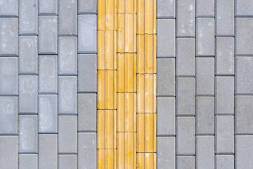 Bright yellow tactile paving on the sidewalk