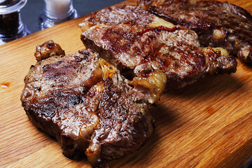 three fried marbled beef steaks on a cutting board