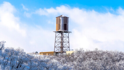Panorama Water tank storage container on a tower at the snowy slope of Wasatch Mountains