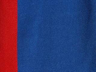 The two-colour texture of the synthetic fabric is blue and red. Nylon texture. Embossed synthetic fibre fabric texture.