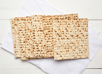 stack of baked square matzo on a white wooden background