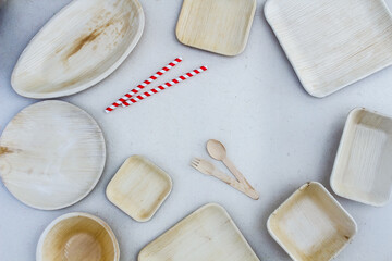 Eco-friendly cutlery consisting of plates, bowls, trays, wooden spoon and and paper straw. Sustainable Living Concept.