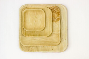 Four Square Areca leaf plates. Top view on a white background.