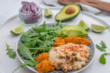 Vegan lunch bowl with quinoa, hummus, chickpeas, avocado, 