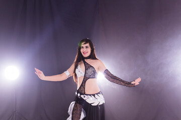 Belly dancer. Young attractive woman dancing tribal fusion on the stage. Oriental exotic dance.