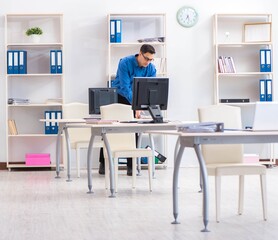 Handsome businessman employee sitting at his desk in office