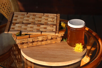 Wooden basket of dendelion flowers and jar of dandelion jam