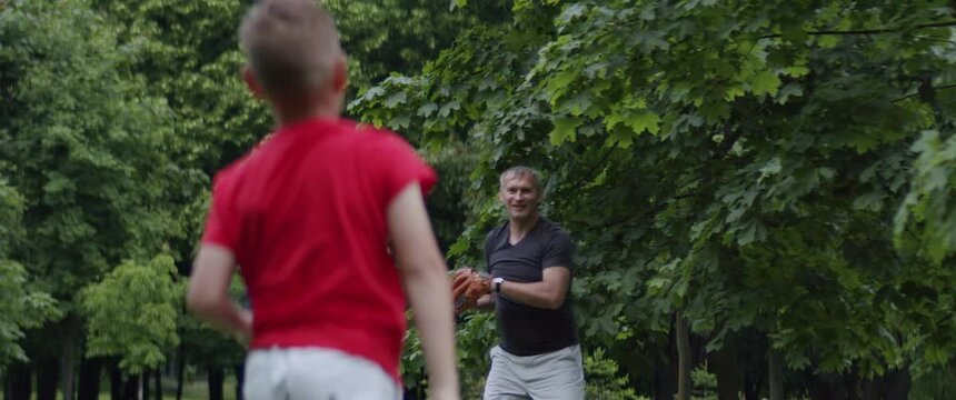 MED Father And Son Playing Baseball Catch In The Park On A Rainy Day. Family Time Spent Together. Shot With 2x Anamorphic Lens