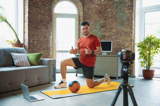 Pull Ups. Young Caucasian Man Training At Home During Quarantine Of Coronavirus Outbreak, Doing Exercises Of Fitness, Aerobic. Recording Video Or Streaming Online. Wellness, Sport, Movement Concept.