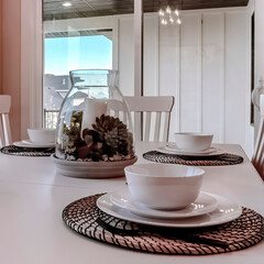 Square Dining table with chairs and tableware arranged around a decorative centerpiece