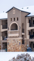 Vertical Beautiful apartment with front gable roof and arched balcony viewed in winter