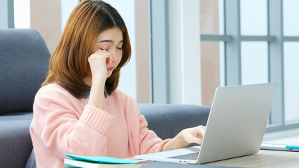 Exhausted asian woman take a break while working with laptop computer at home office, Tried asia female  take a nap from overwork, Exhausted office girl asleep when working at home