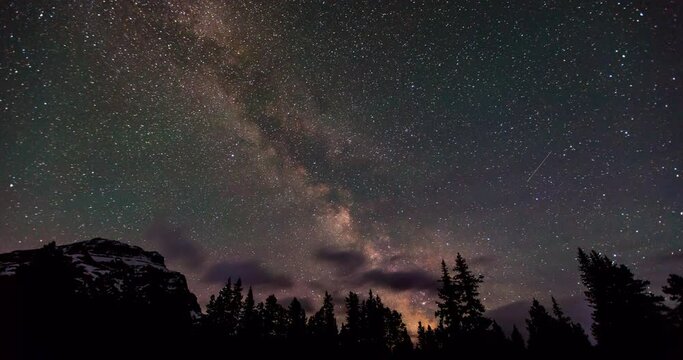 Time lapse shot of Milky Way over mountain and trees against sky at night - Banff, Canada