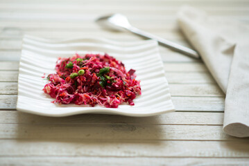 beetroot salad with greens and cabbage on grey background