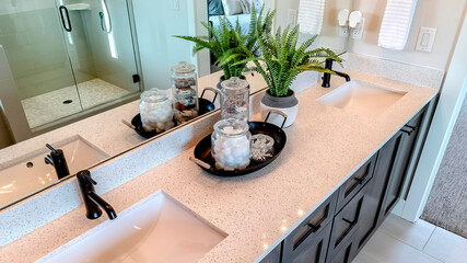 Panorama Two sinks with black faucet on white countertop over cabinets on tile floor