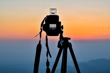 camera on tripod against sunset