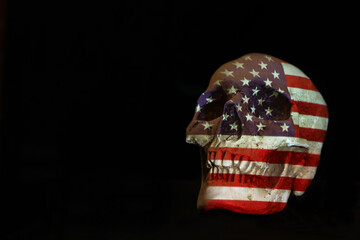 An isolated white skull with the American, US United State of America flag projected over it. Plain black background