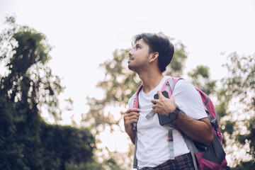 Young Asian man traveling backpacker in the forest, Concept of nature tourism
