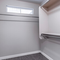 Square crop Hanging metal clothes rods inside empty closet interior of a new home