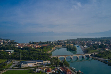 Railway arch bridge over the Mincio River, Peschiera del Garda, Italy. Aerial view of Lake Garda