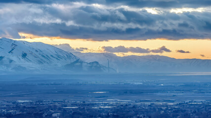 Panorama crop Salt Lake City Utah landscape against snowy mountain and cloudy sky at sunset