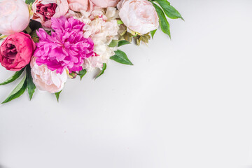 Flat lay of flowers and green leaves. Tender Peonies and chrysanthemums bloom pattern, composition for postcards on white background.