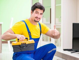 Male professional serviceman repairing tv at home