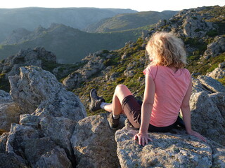 Jeune femme blonde seule face au soleil couchant en montagne tranquillité luxe calme et volupté...