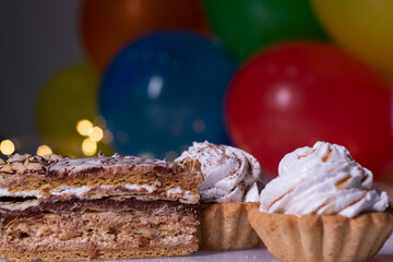 festive cupcake on the background of multi-colored balloons and lights. party, birthday concept. Copy space. High quality photo
