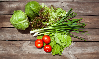 
Healthy eating Fresh farm vegetables tomatoes, cucumbers, salad lola rossaa and lola bianca, green onions, cabbage. Non-GMO Organic Vegetables, 100% Vegan Vegetarian Slimming Diet Wooden Background