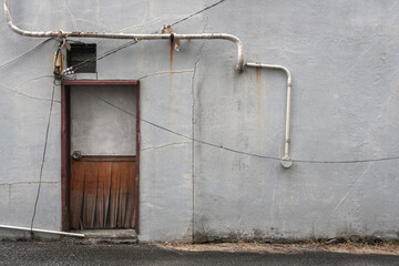コンクリートの壁と扉と配管