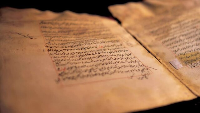 Ural, Russia - June 15, 2020:An open Muslim book lies on the table in the dark