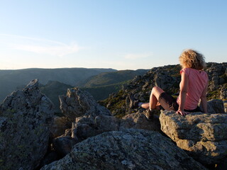 jeune femme blonde devant le vide de la montagne du Caroux au soleil couchant du parc naturel du haut languedoc