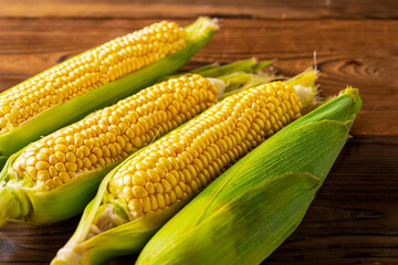 Corn cobs on wood background.